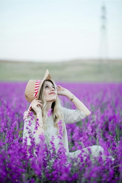 mujer sonriendo y mirando al cielo en un campo de lavanda